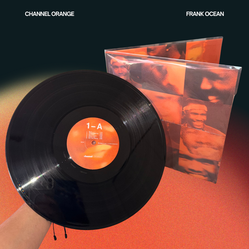 Hand holding a Frank Ocean Channel Orange vinyl record displaying side 1-A with the glossy gatefold sleeve jacket displayed in the background.